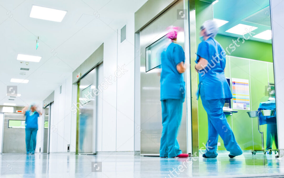 stock-photo-blurred-figures-wearing-medical-uniforms-in-hospital-surgery-corridor-84258409